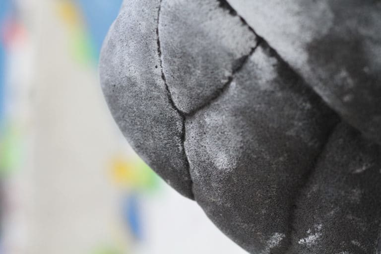 Nahaufnahme eines schwarzen Bouldergriff an der Kletterwand