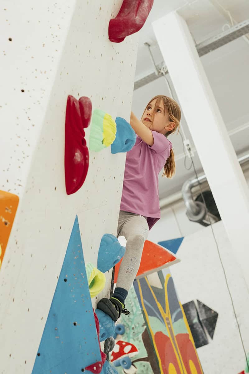 Action im Bouldertraining an der Kletterwand in der Halle